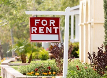 Red for rent sign up in front of an apartment building